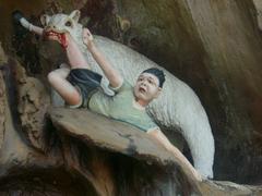 Boy being eaten by a bear statue in Haw Par Villa