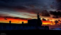 lighthouse at sunset with a magical aura