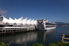 Canada Place in Vancouver with ships and calm water reflection