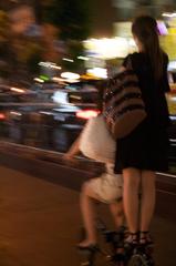 woman standing on the rack of a folding bike in Osaka