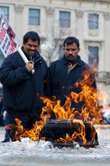 People tending to a permanent fire outdoors