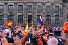 Crowd waving to King Willem-Alexander, Princess Beatrix, and Queen Máxima on Dam Square after Beatrix's abdication