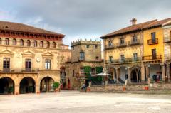 Wide view of a large square in Barcelona with people walking and historic buildings around