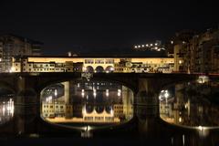 Night view of Ponte Vecchio and Ponte Santa Trinita from Ponte alla Carraia in Florence, Italy.