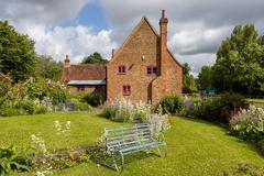 stone farmhouse with wooden shutters surrounded by lush grass