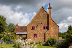 Thatched cottage with stone walls surrounded by lush greenery at Chiltern Open Air Museum