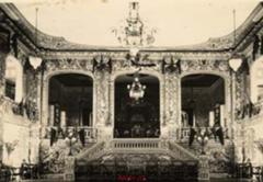 Interior of An Dinh Palace Theatre in 1928, featuring rows of chairs and grand staircase