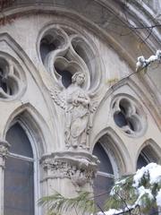 Angel under the Rose window on the Duomo facade at Vajdahunyad Castle