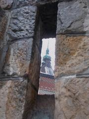 The Apostles Tower viewed through a stone gate arrow slit at Vajdahunyad Castle