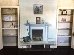 fireplace area between two almost empty bookshelves