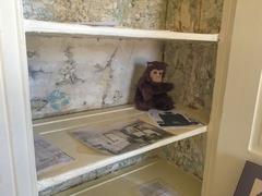 shelf in a closet with papers and a stuffed monkey at Edgar Allan Poe National Historic Site