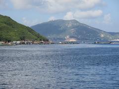 a scenic coastline view of Tung Lung Chau with green hills and rocky shores