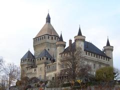 Chateau de Vufflens with surrounding greenery under a clear sky