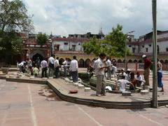 Cleaning the central pool at Fatehpuri Masjid