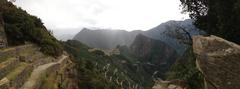 sunset view of Machu Picchu ruins from Sun Gate with light rain