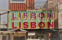 Panoramic view of Lisbon, Portugal with traditional red rooftops and historic buildings under a blue sky