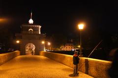 Night view of Ponte Milvio with a fisherman in Rome, Italy