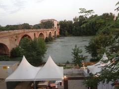 Ponte Milvio at sunset with people walking on the bridge