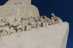 Panoramic view of Belem Tower in Lisbon with tourists and clear blue sky