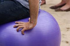 Man sitting on an exercise ball at PS1 Summer Warm Up 2010