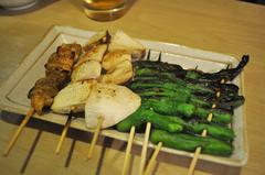 Assorted yakitori items including kawa (chicken skin), yamaimo (sticky yam), shishitou (Japanese pepper).