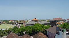 A bustling street in Denpasar with various vehicles and outdoor vendors