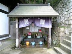 A small shrine with a water urn at Suinomi Jizoin in Yao City, Osaka Prefecture