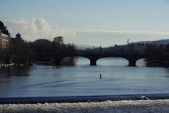 Charles Bridge in Prague during the day with tourists and a view of gothic towers