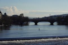 Charles Bridge at dusk with illuminated towers and statues