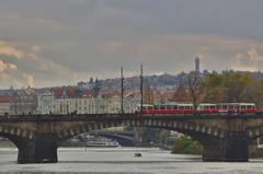 Bridge crossing over city water with metro and clouds