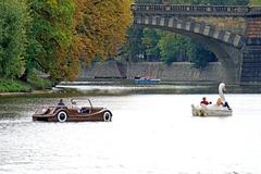 Car-shaped paddle boat on a weir in a river