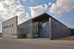 Front view of MOCAK Museum of Contemporary Art in Kraków with large glass windows and concrete structure