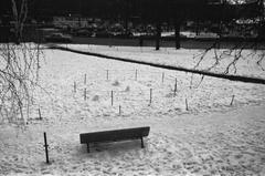 Snowy Katajanokan puisto (Tove Jansson Park) with bench and fenced flowerbed in Helsinki