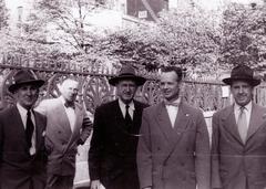 Five men wearing suit jackets in front of a wrought iron fence, Charles Peterson on the right