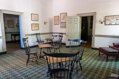 room with Windsor chairs around tables on a patterned carpet in City Tavern