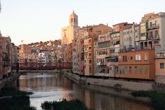 Colorful buildings along Onyar River with Pont de les Peixateries Velles and Girona Cathedral in the background