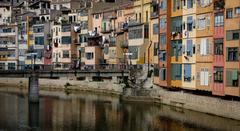 Colorful houses along Onyar River with Sant Agustí Bridge in Girona