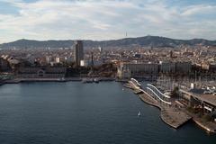 Aerial view of Barcelona cityscape with buildings, roads, and coastline