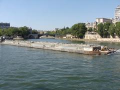 pushed barge on the Seine River in Paris with Île Saint-Louis and Pont-Sully in the background