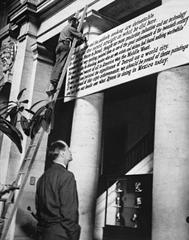 Museum Director overseeing installation of a sign defending Diego Rivera's murals