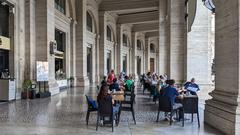 People sitting outside cafes under covered walkway in Piazza della Repubblica, Rome