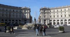 Piazza della Repubblica at dusk featuring the Colonna dell'Immacolata and surrounding historic buildings in Rome