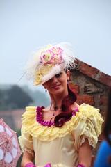 woman in historical dress and fashion hat near Prague Castle