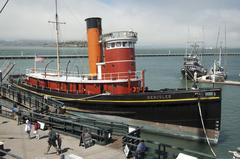 red and black painted tugboat built in 1907