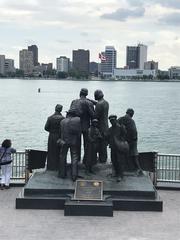 The Gateway to Freedom Monument in Detroit, Michigan with Detroit River and Windsor, Canada in the background