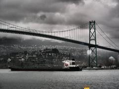 Caution sign under Lions Gate Bridge on a stormy day