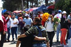 woman hugging a child walking near a cemetery on Day of the Dead