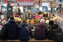 Gwangjang Market vendors serving food for customers in Seoul, South Korea