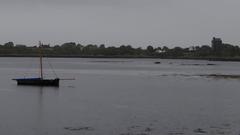 Dunguaire Castle overlooking its bay with reflection on the water