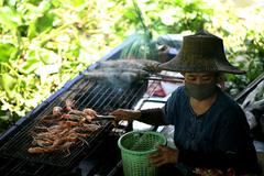 Woman selling food at Taling Chan floating market in Bangkok